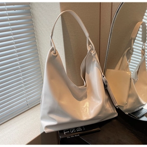 Detailed macro view of ivory hobo bag featuring smooth glossy leather and a mini pouch