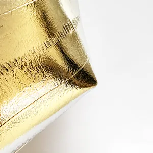 Primer plano macro de tela dorada metálica con textura plisada irregular y brillo suave