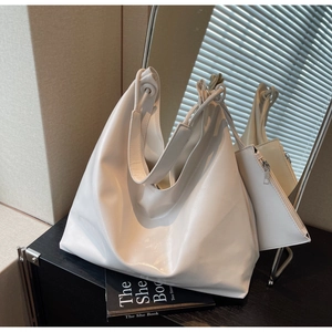 Close-up of white Hobo tote bag showing textured PU leather with small matching pouch