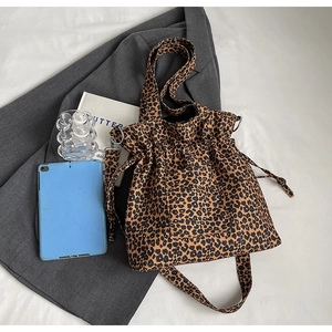 Close-up of leopard print canvas tote bag with drawstring closure and metal ring detail