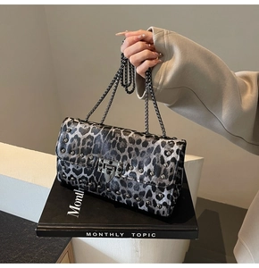 Gros plan du sac à bandoulière léopard avec clous argentés et boucle métallique