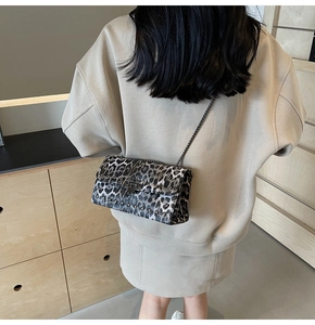 Mannequin portant un sac léopard vintage avec chaîne en métal et détails de rivets