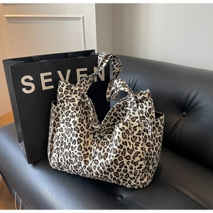 Dettaglio della tasca laterale e della trama leopardata sulla grande borsa tote in tela