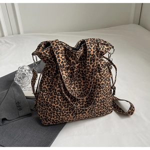Detail of leopard print canvas tote bag with adjustable drawstring and metal strap hooks