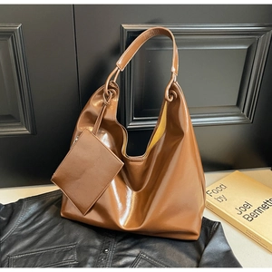 Detail of glossy brown large hobo bag with knotted handle and matching mini pouch
