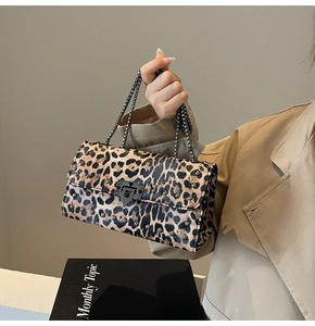 Détail d'un sac à bandoulière léopard avec rivets métalliques et chaîne