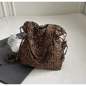 Detail view of the drawstring closure and silver hardware on a leopard print tote bag