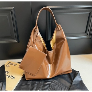 Detail view of glossy brown large-capacity tote bag with matching zippered pouch accessory