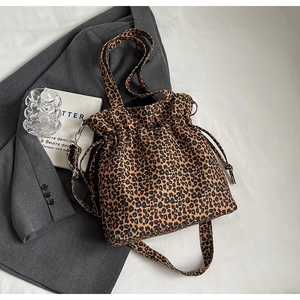 Detail of leopard print drawstring tote bag with adjustable shoulder strap and wide handle