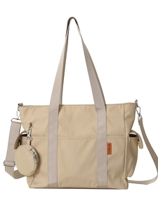 Versatile beige canvas tote bag with adjustable wide strap and round coin purse attachment