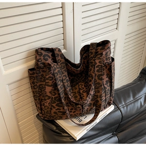 Dettaglio della borsa tote in tela leopardata con spalline larghe e tasca laterale