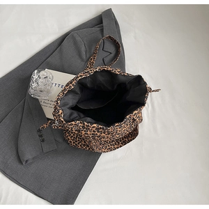 Detail of leopard print canvas tote bag featuring black inner lining and open interior pocket