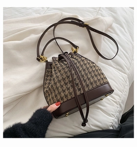 Detail of drawstring closure and houndstooth texture on vintage bucket bag