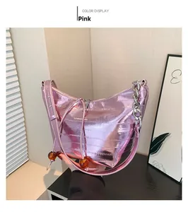 Detalle de bolso hobo rosa metalizado con cadena de plata gruesa y cuentas de ámbar