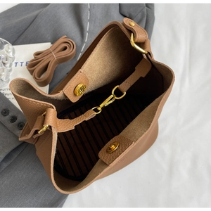 Vue détaillée du sac seau marron avec fermoirs dorés et doublure à rayures