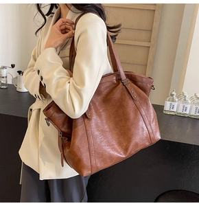 Detail of vintage brown tote bag with star-shaped metal studs and retro oil wax texture