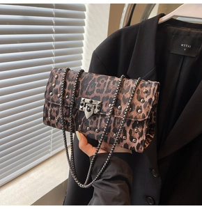 Détail du sac léopard avec clous argentés et bandoulière chaîne en décor de studio