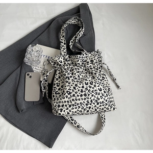 Detail of leopard print canvas bag showing drawstring closure and front pocket feature