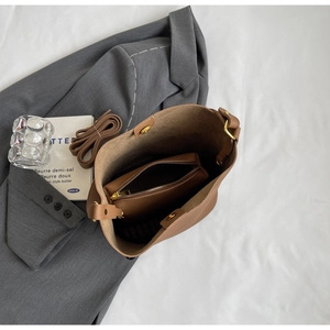 Vue détaillée du sac seau en cuir marron avec pochette intérieure et dorures