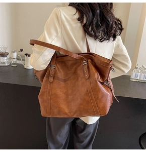 Detail of vintage brown tote bag with metal star rivets shown in a cafe setting