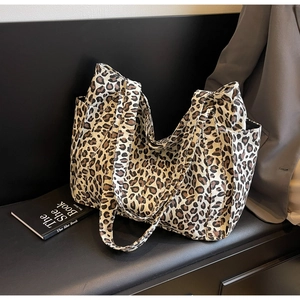 Detailed side view of leopard print canvas tote bag with side pocket and long straps