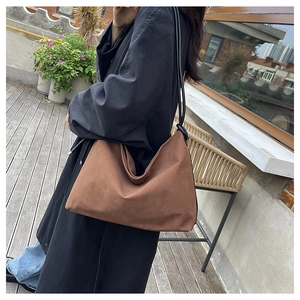 Photo extérieure d'un grand sac cabas hobo marron avec de fines bandoulières noires