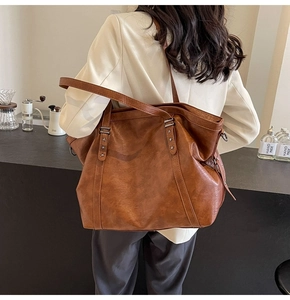 Detail of a brown retro tote bag with star-shaped rivets in a stylish cafe setting