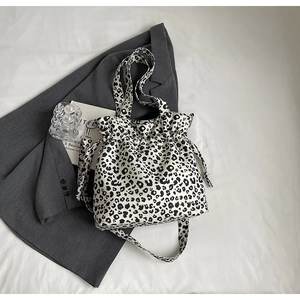 Detail of leopard print canvas tote with drawstring closure and adjustable shoulder strap