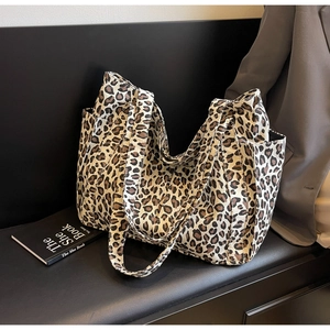Dettaglio della borsa tote leopardata capiente con tasche laterali su una panca