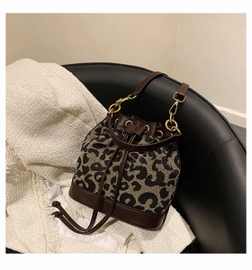 Detail of vintage leopard print bucket bag with drawstring closure and golden hardware