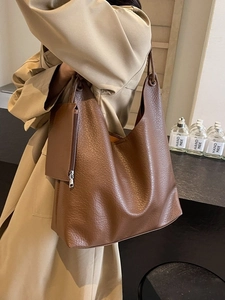 Grand sac cabas marron en cuir grainé avec pochette zippée porté par un mannequin