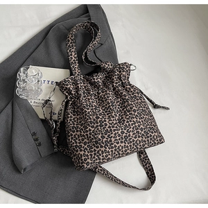 Close-up of leopard print canvas bucket bag with drawstring closure and metal hardware