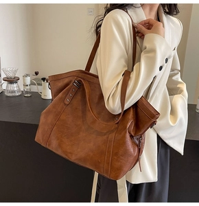 Close-up of brown tote bag with metal star rivets on shoulder strap and faux leather texture