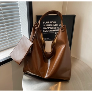 Detail of dark brown large capacity faux leather tote bag with a small matching pouch