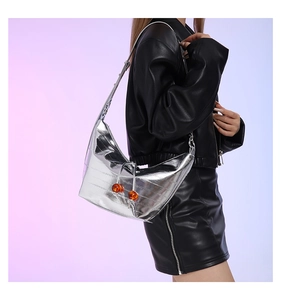 Detalle del bolso de media luna plateado con cuentas naranjas y correa ajustable de moda