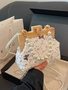 White fabric shell bag with sequined butterfly, wooden frame, and pearl strap handles