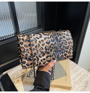 Détail du sac à main léopard avec des clous métalliques et un fermoir géométrique chic