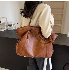 Detail of vintage reddish-brown tote bag featuring star rivets and drawstring design