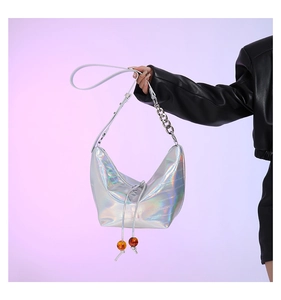 Detalle de bolso hobo holográfico plateado con textura de cocodrilo y cuentas de ámbar