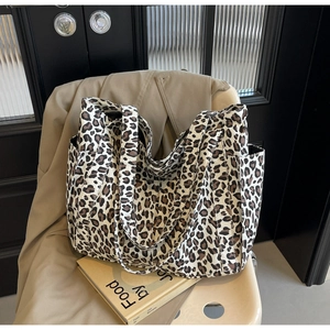 Dettaglio della borsa tote in tela leopardata con tasca laterale in un set elegante