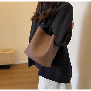 Détails du sac seau en cuir marron foncé avec logo de marque et finitions métalliques