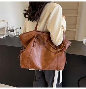 Brown faux leather tote bag with star rivets shown in a cafe setting detail view
