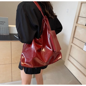 Detail of dark red high-gloss shoulder bag showing large capacity and shiny PU leather texture