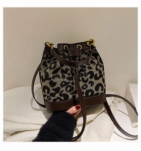 Detail of leopard print bucket bag with drawstring closure and gold ring hardware