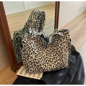 Dettagli di una borsa tote in tela leopardata con pratiche tasche laterali esterne