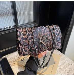 Détail du sac bandoulière imprimé léopard avec rivets argentés et chaîne métallique