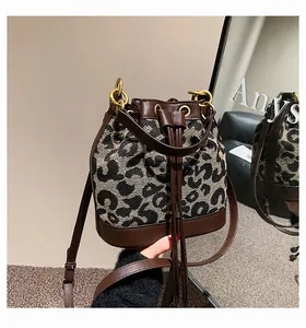 Detail of leopard jacquard bucket bag with brown leather drawstring and golden hardware