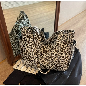 Dettaglio della borsa tote in tela leopardata con tasche laterali e manici larghi