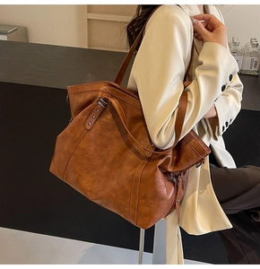 Brown leather tote bag featuring star studs shown on model in a minimalist style