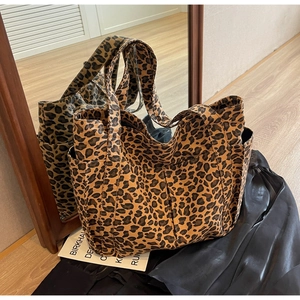Vista dettagliata della borsa tote in tela leopardata con tasche laterali e trama del tessuto